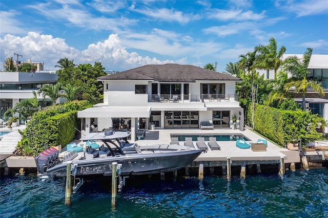 back of property with a patio area and a water view