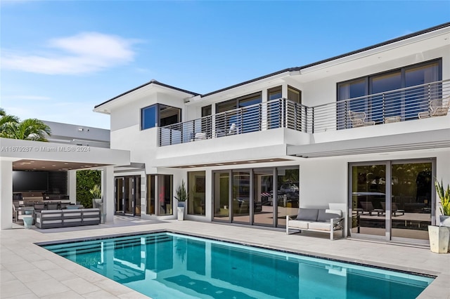 back of property featuring a patio area, a balcony, and an outdoor hangout area