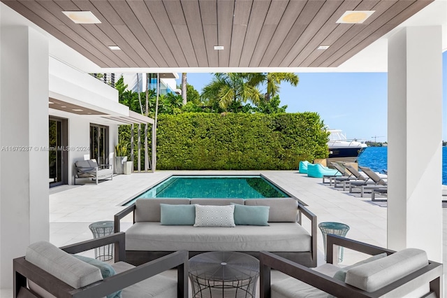 view of pool with a water view, an outdoor living space, and a patio