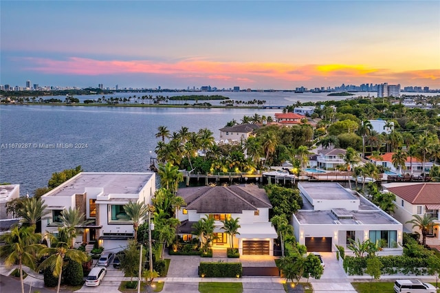 aerial view at dusk featuring a water view