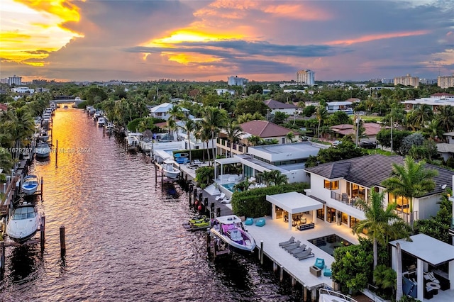 aerial view at dusk featuring a water view