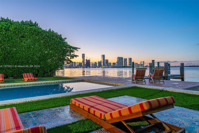 pool at dusk featuring a water view