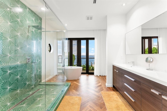 bathroom featuring french doors, parquet floors, vanity, a water view, and independent shower and bath