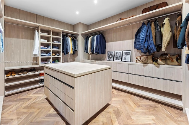 walk in closet with light parquet flooring