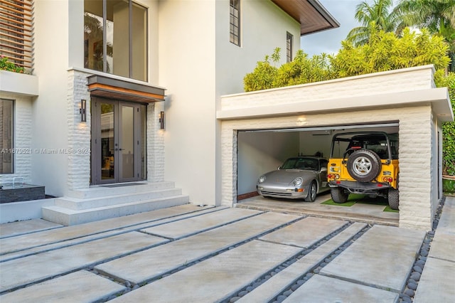 view of exterior entry with french doors and a garage