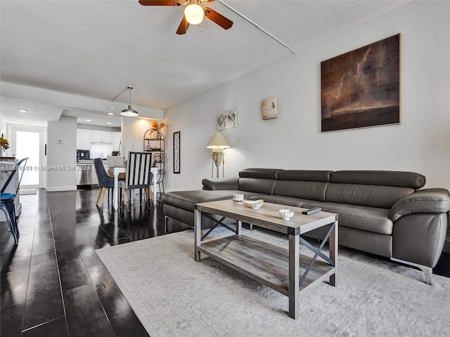 living room with dark hardwood / wood-style floors and ceiling fan