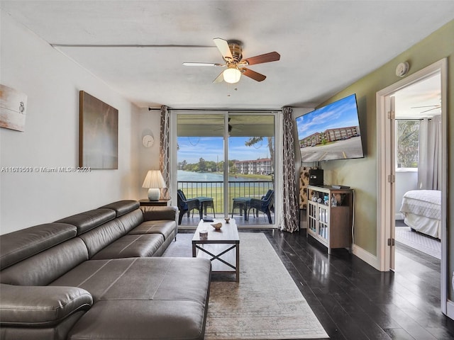 living room featuring ceiling fan and dark hardwood / wood-style floors