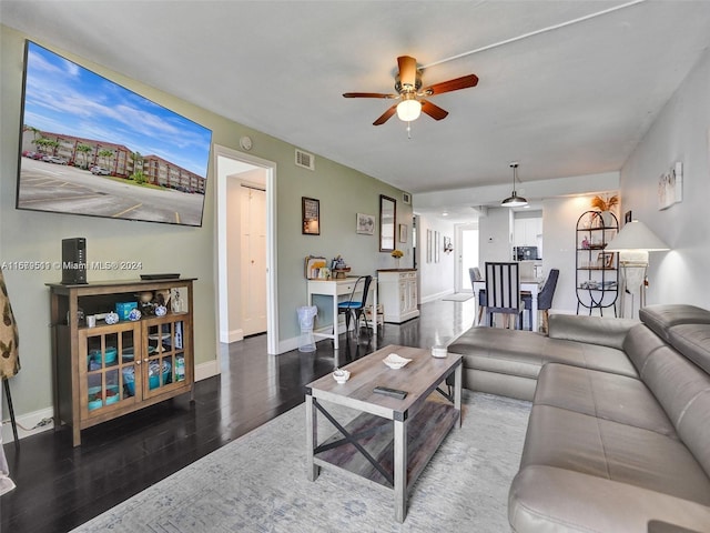 living room featuring ceiling fan and dark hardwood / wood-style floors