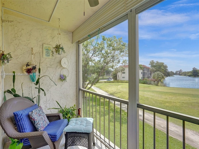 sunroom with a water view and ceiling fan