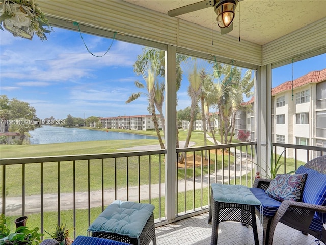 sunroom / solarium featuring a water view and ceiling fan