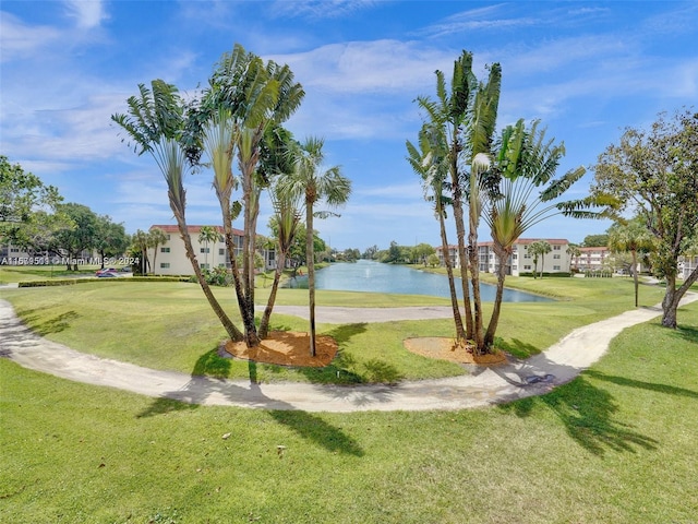 view of property's community with a water view and a yard