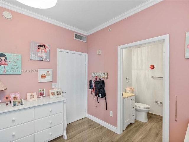 interior space with light hardwood / wood-style flooring, ensuite bathroom, and crown molding