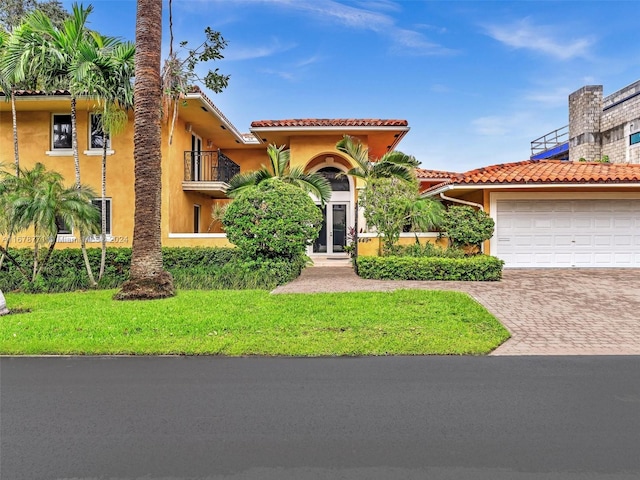 449 Isle Of Palms Dr, Fort Lauderdale, FL 33301 - mediterranean / spanish-style house featuring a tiled roof, a front yard, a garage, decorative driveway, and stucco siding