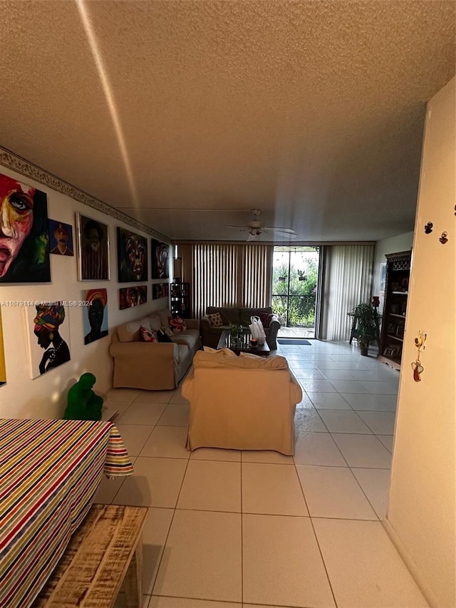 living room with ceiling fan, a textured ceiling, and light tile patterned floors