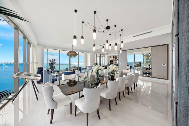 dining room featuring a water view and a notable chandelier