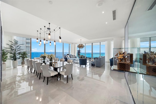 dining area featuring a water view, marble finish floor, visible vents, and a chandelier