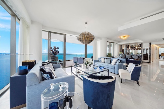 living room with expansive windows, a water view, a healthy amount of sunlight, and a chandelier