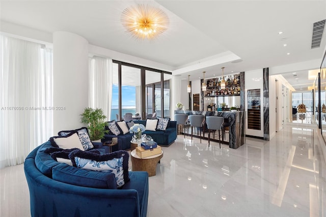 living room featuring indoor bar and an inviting chandelier