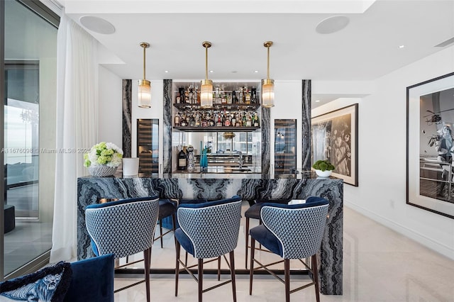 bar featuring wet bar, decorative light fixtures, and baseboards