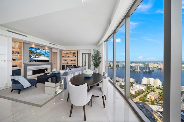 dining space with a fireplace and a water view