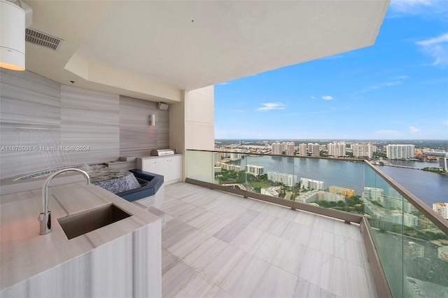 balcony featuring a water view and sink