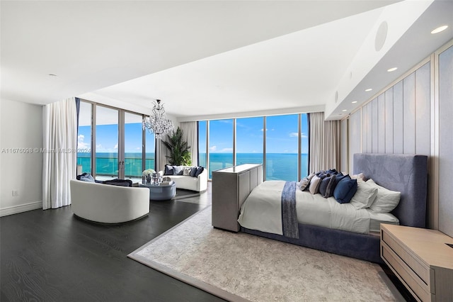 bedroom featuring wood-type flooring, multiple windows, and a water view