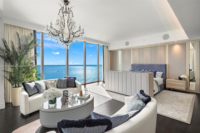 living room featuring a wall of windows, dark hardwood / wood-style flooring, a water view, and a chandelier