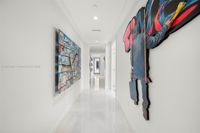 hallway with speckled floor, recessed lighting, visible vents, and baseboards