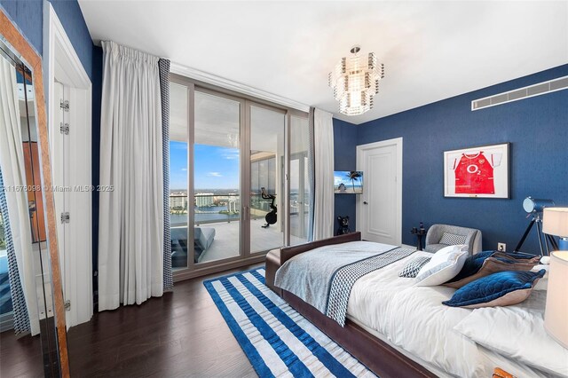 bedroom with access to outside, dark hardwood / wood-style floors, and a chandelier