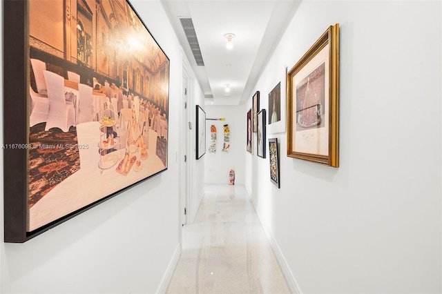 hallway with visible vents and baseboards