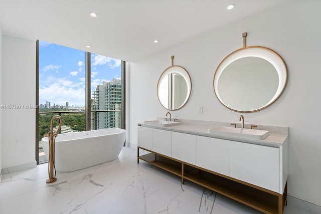 bathroom with a bathing tub, vanity, and floor to ceiling windows