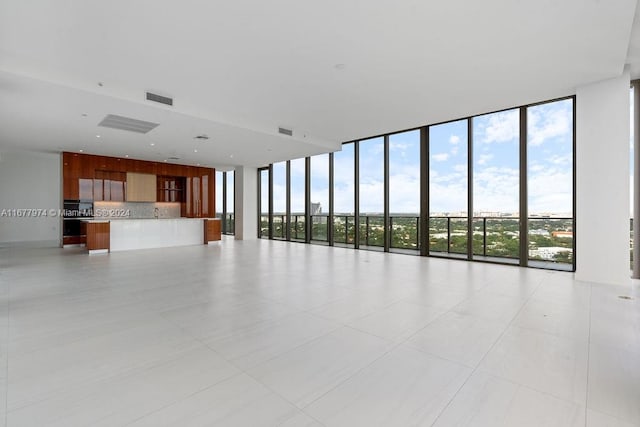 empty room with expansive windows and light tile patterned flooring