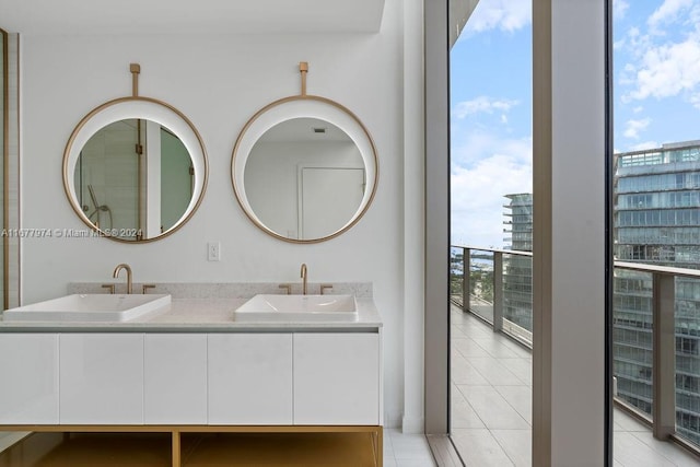 bathroom featuring tile patterned flooring, vanity, and a healthy amount of sunlight