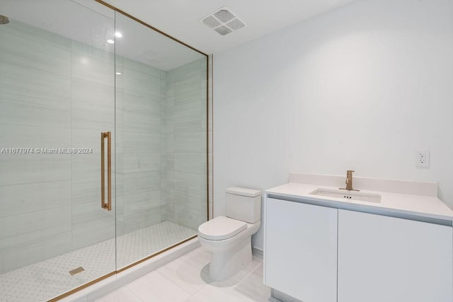 bathroom with tile patterned floors, vanity, an enclosed shower, and toilet