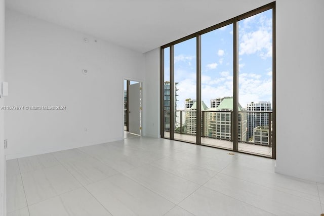 tiled spare room featuring expansive windows