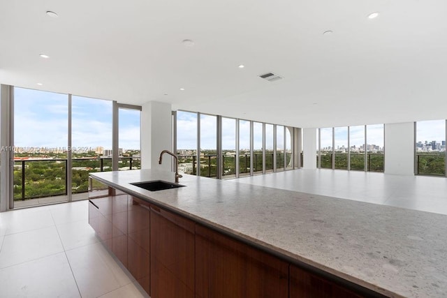 kitchen with a wall of windows, sink, and light tile patterned floors