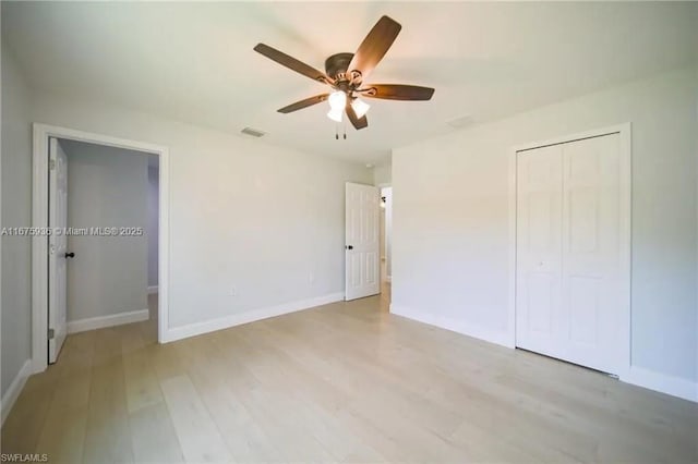 unfurnished bedroom featuring ceiling fan, a closet, and light hardwood / wood-style flooring