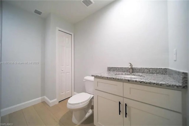 bathroom featuring vanity, hardwood / wood-style flooring, and toilet