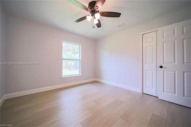 unfurnished bedroom with ceiling fan, a closet, and light wood-type flooring