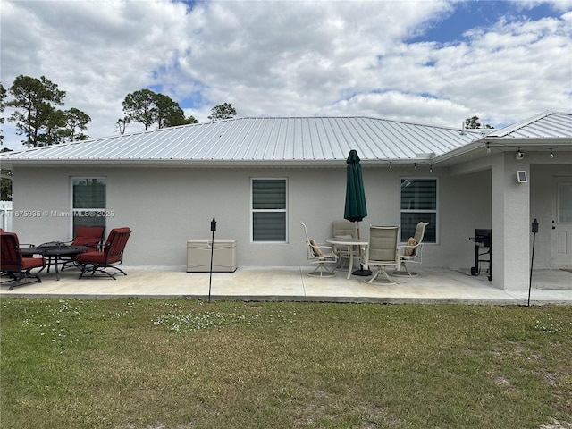 rear view of property with a yard and a patio