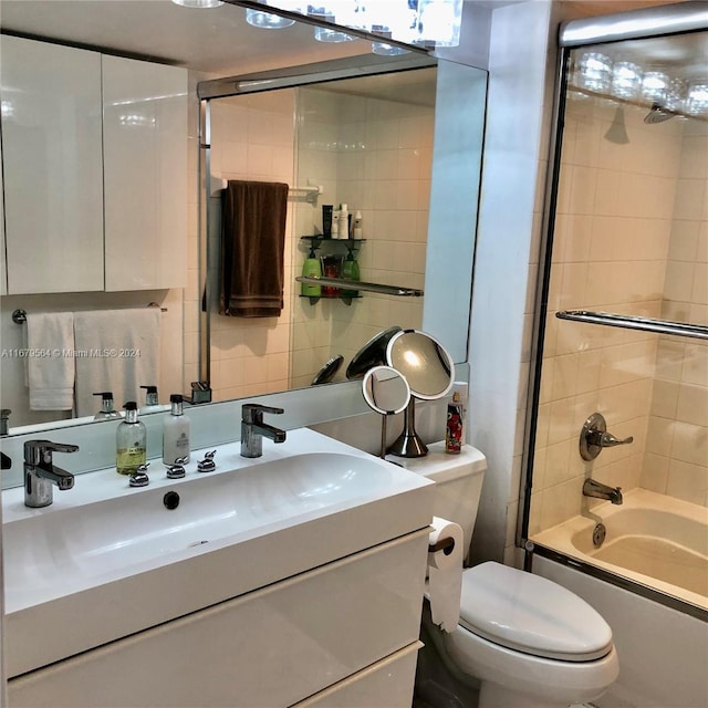 full bathroom featuring vanity, toilet, tasteful backsplash, and enclosed tub / shower combo