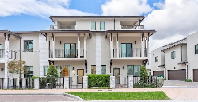 multi unit property featuring a balcony and a garage