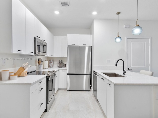 kitchen with kitchen peninsula, white cabinets, sink, decorative light fixtures, and stainless steel appliances