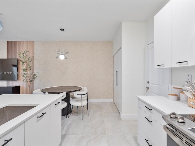 kitchen with stainless steel range, white cabinetry, and pendant lighting