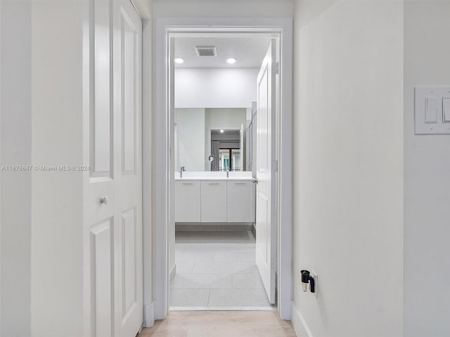 corridor featuring light hardwood / wood-style floors and a textured ceiling