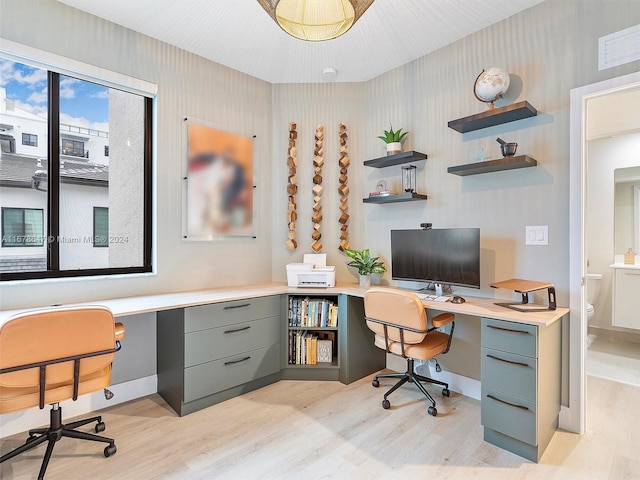 home office featuring built in desk and light hardwood / wood-style flooring