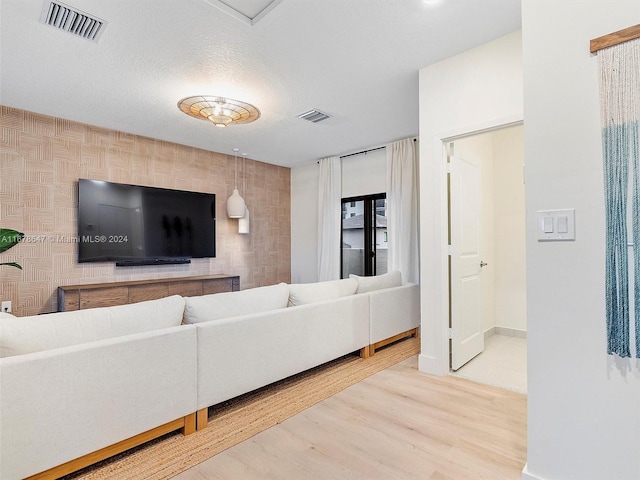 living room with a textured ceiling and wood-type flooring