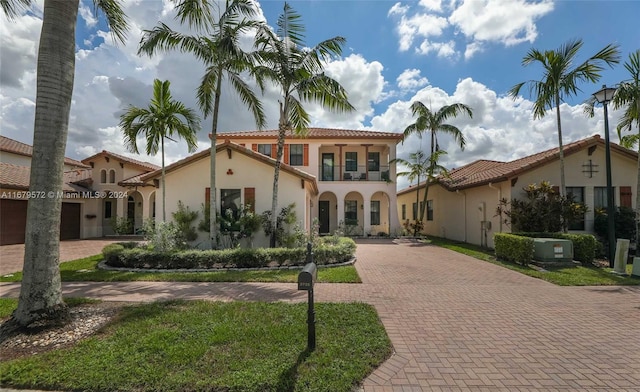 mediterranean / spanish home with a front lawn