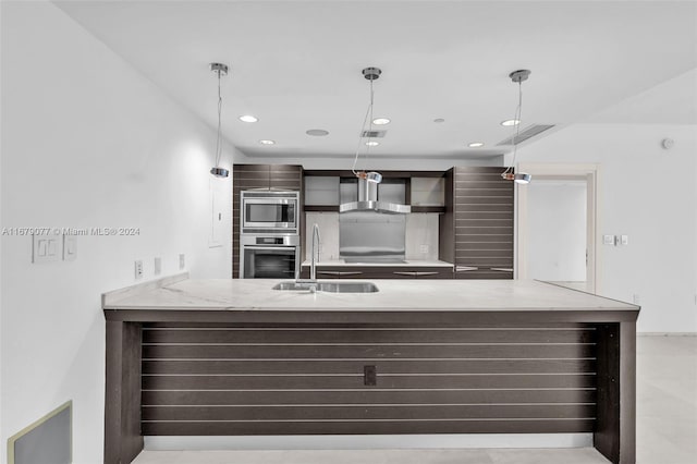 kitchen with kitchen peninsula, stainless steel appliances, wall chimney range hood, sink, and hanging light fixtures