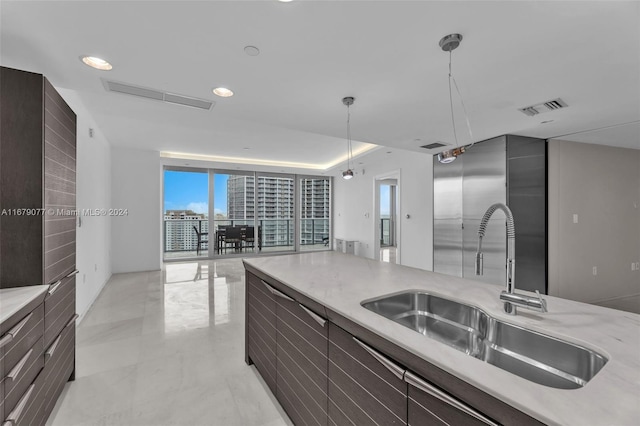 kitchen with floor to ceiling windows, sink, and hanging light fixtures